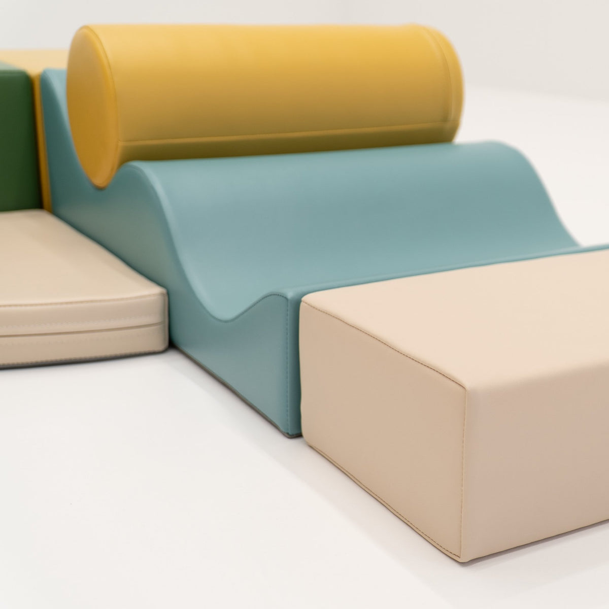 2. Close-up of IGLU Explorer Set showing pastel turquoise, yellow, and beige foam blocks with rounded and flat shapes