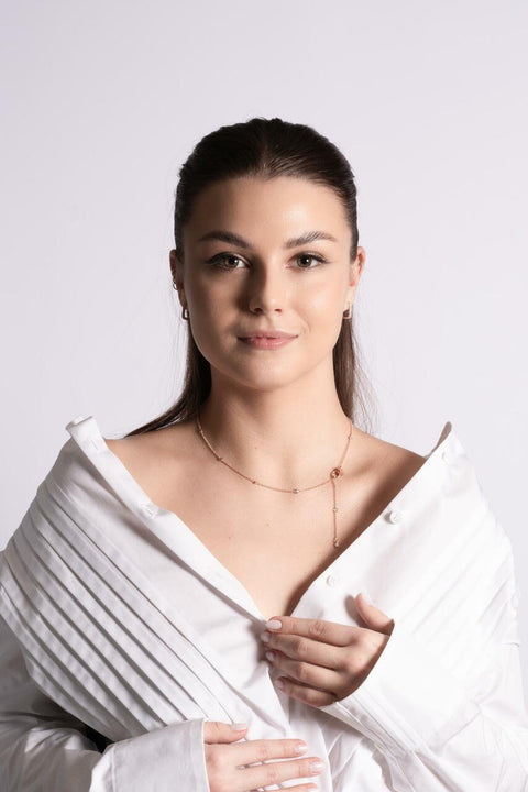 1. Women's Illumi Doubled S Necklace in rose gold worn with white blouse, showcasing elegant design and sparkle