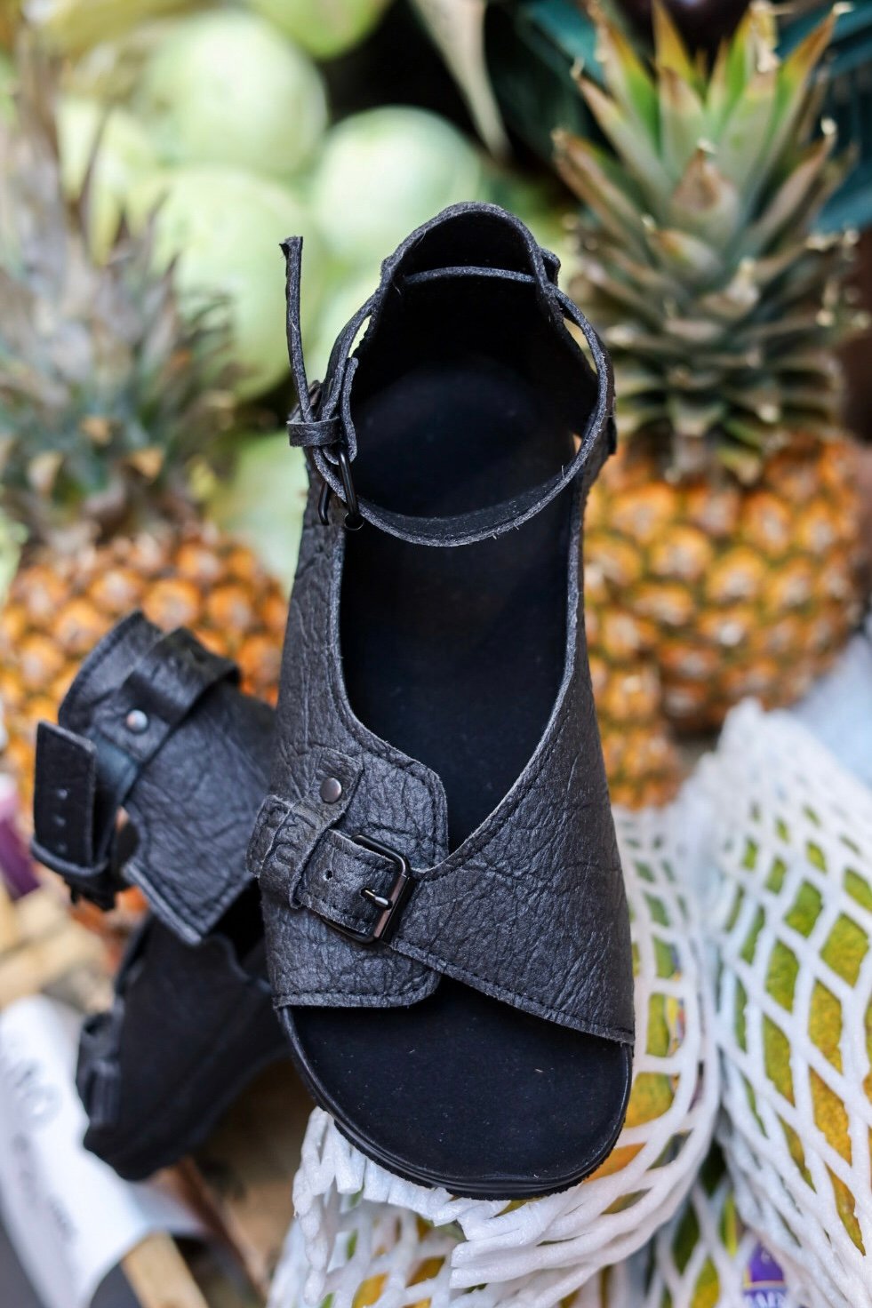 2. Close-up of black TOKU Athens Vegan Sandals with pineapples, highlighting Piñatex material