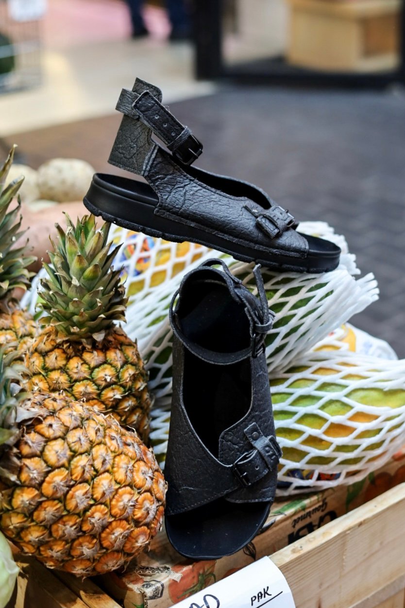 1. TOKU Athens Vegan Sandals in black displayed on pineapples, showcasing eco-friendly design