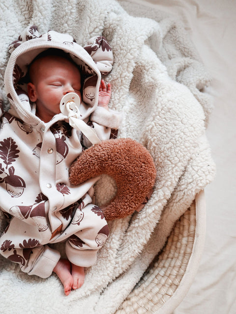 5. Sleeping baby in Zezuzulla eared jumpsuit with acorn print, cuddling a plush toy