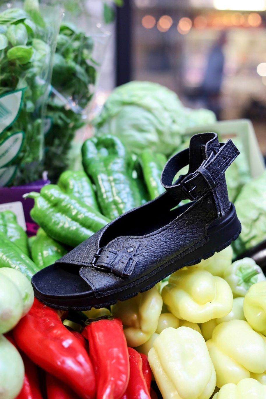 3. Black TOKU Athens Vegan Sandals on colorful vegetables, emphasizing sustainable style