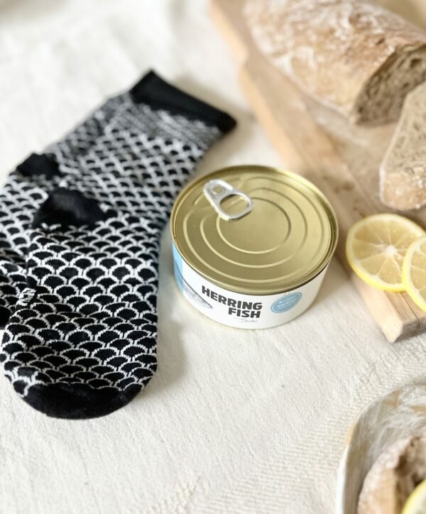 2. SEIK Herring Socks in a Can, unisex, black and white pattern, displayed with bread and lemon slices