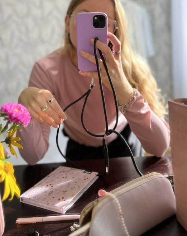 1. Woman using SEIK Universal Phone Strap in Midnight, showcasing hands-free phone accessibility