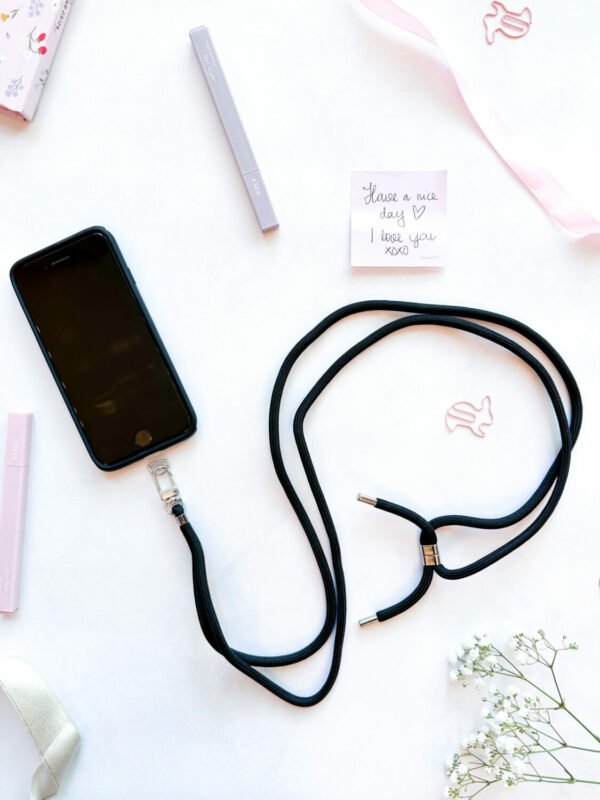 3. SEIK Universal Phone Strap in Midnight with phone, shown in flat lay setting