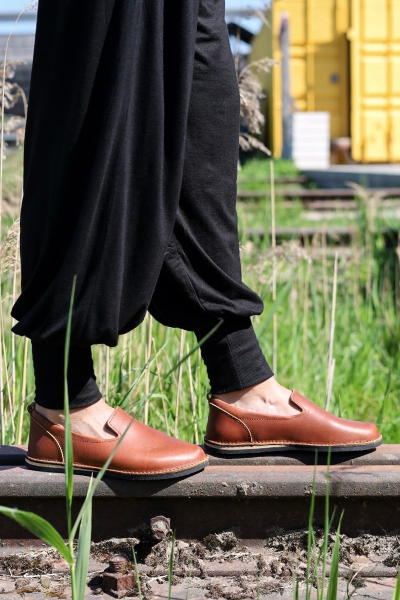 3. Lifestyle side view of Omaking London classic brown shoes in TOKU style worn by a person on a railway track