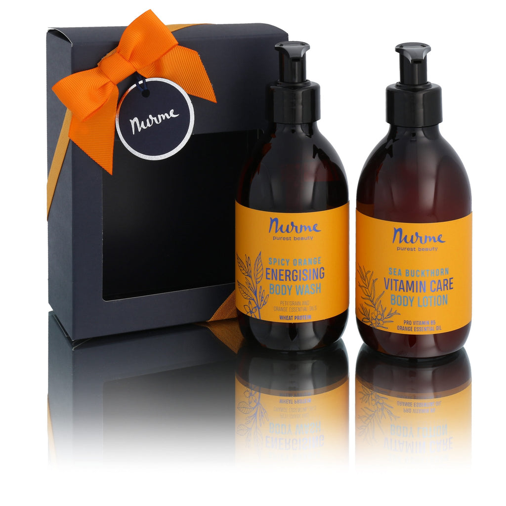 1. Nurme Spice Orange Natural Body Care Set with energising body wash and vitamin care body lotion in pump bottles, shown in gift packaging with orange ribbon