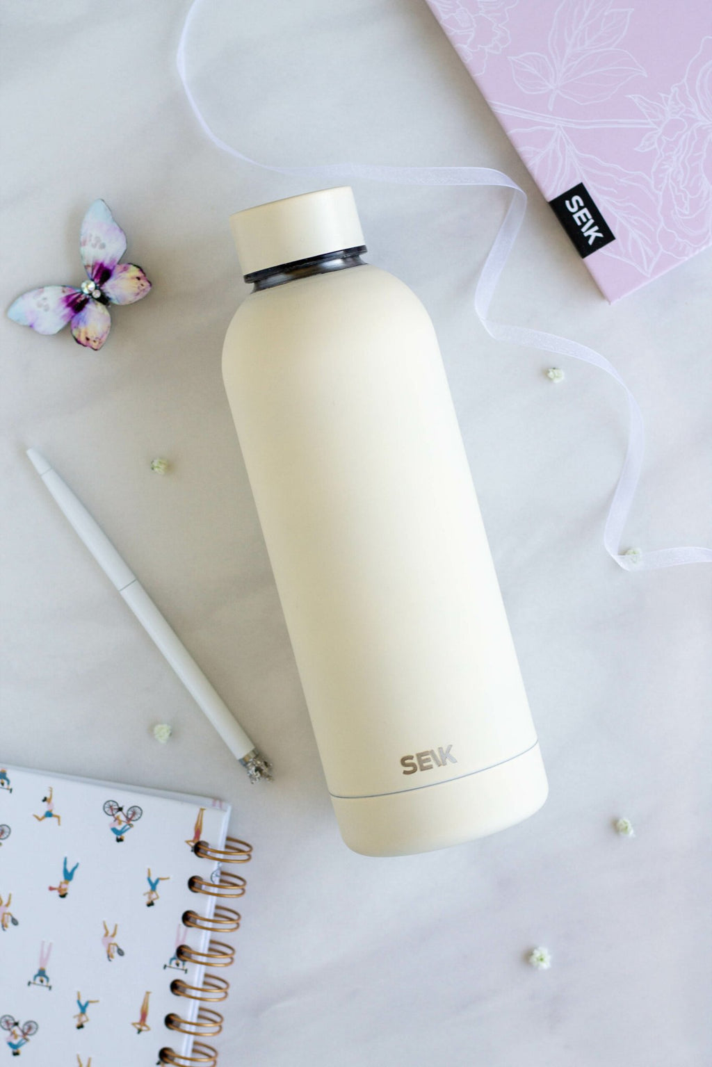 2. SEIK yellow water bottle with matte finish on a desk with a pen and notebook