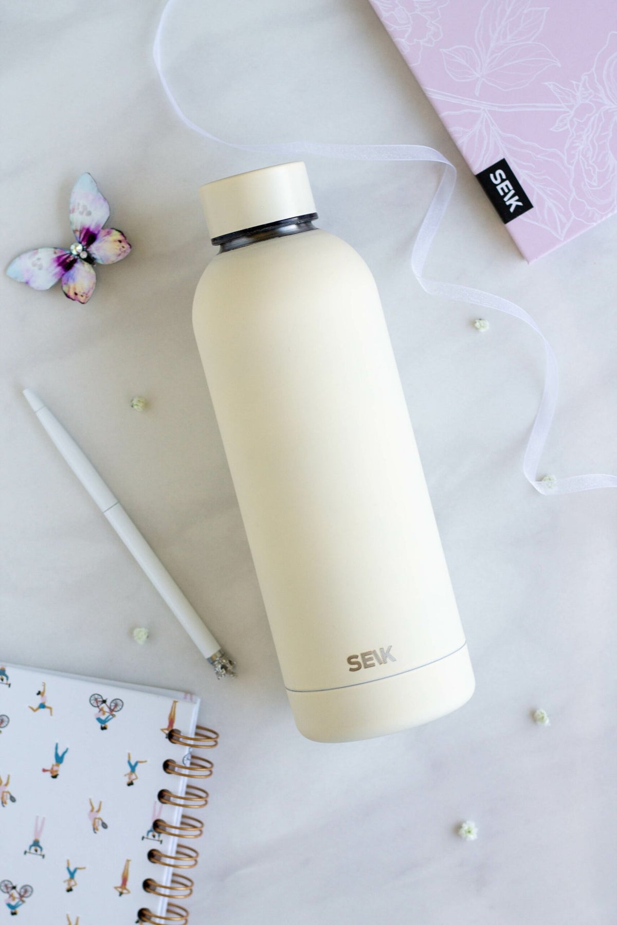 2. SEIK yellow water bottle with matte finish on a desk with a pen and notebook