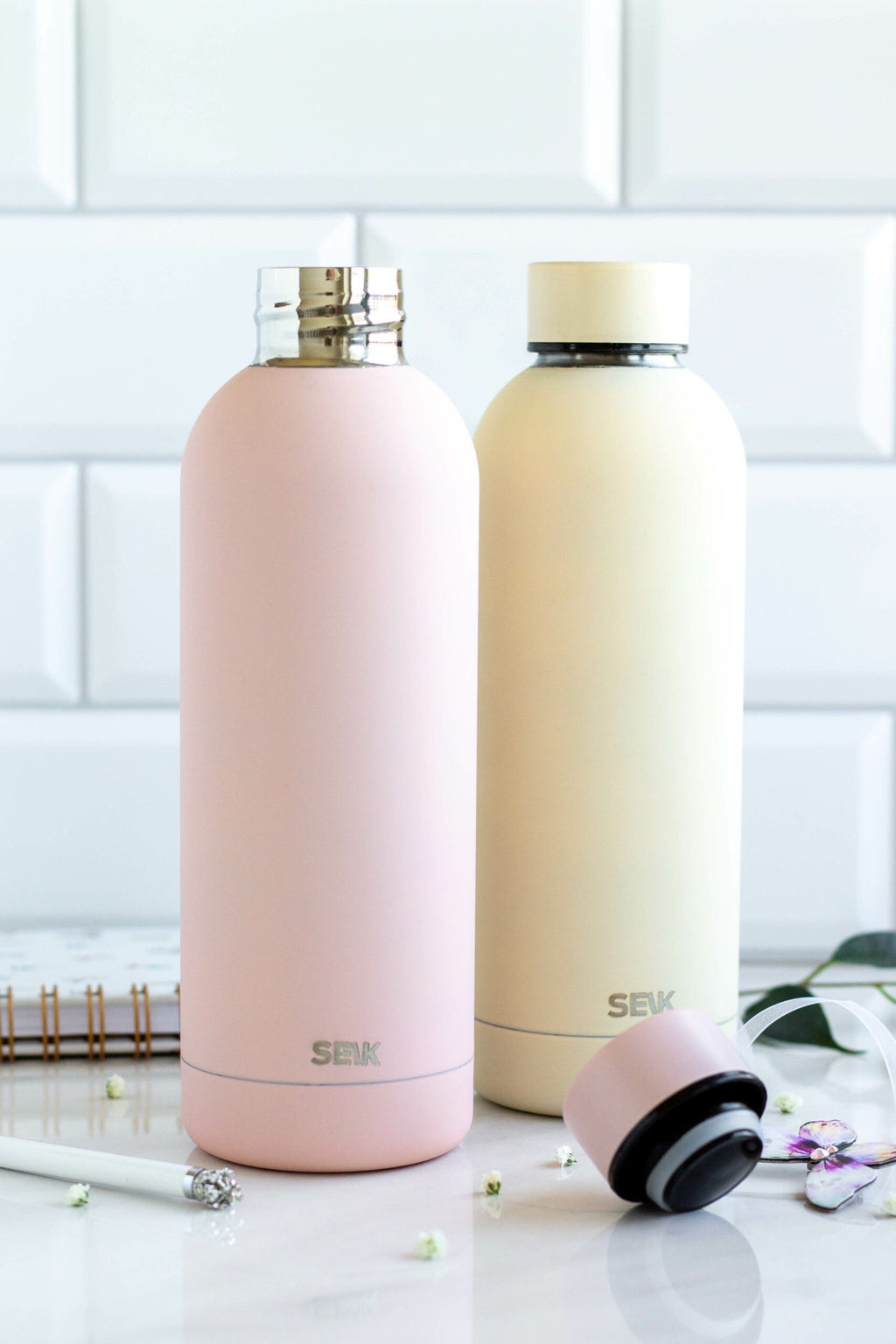 1. SEIK yellow and pink water bottles with vacuum-insulated caps on a marble surface