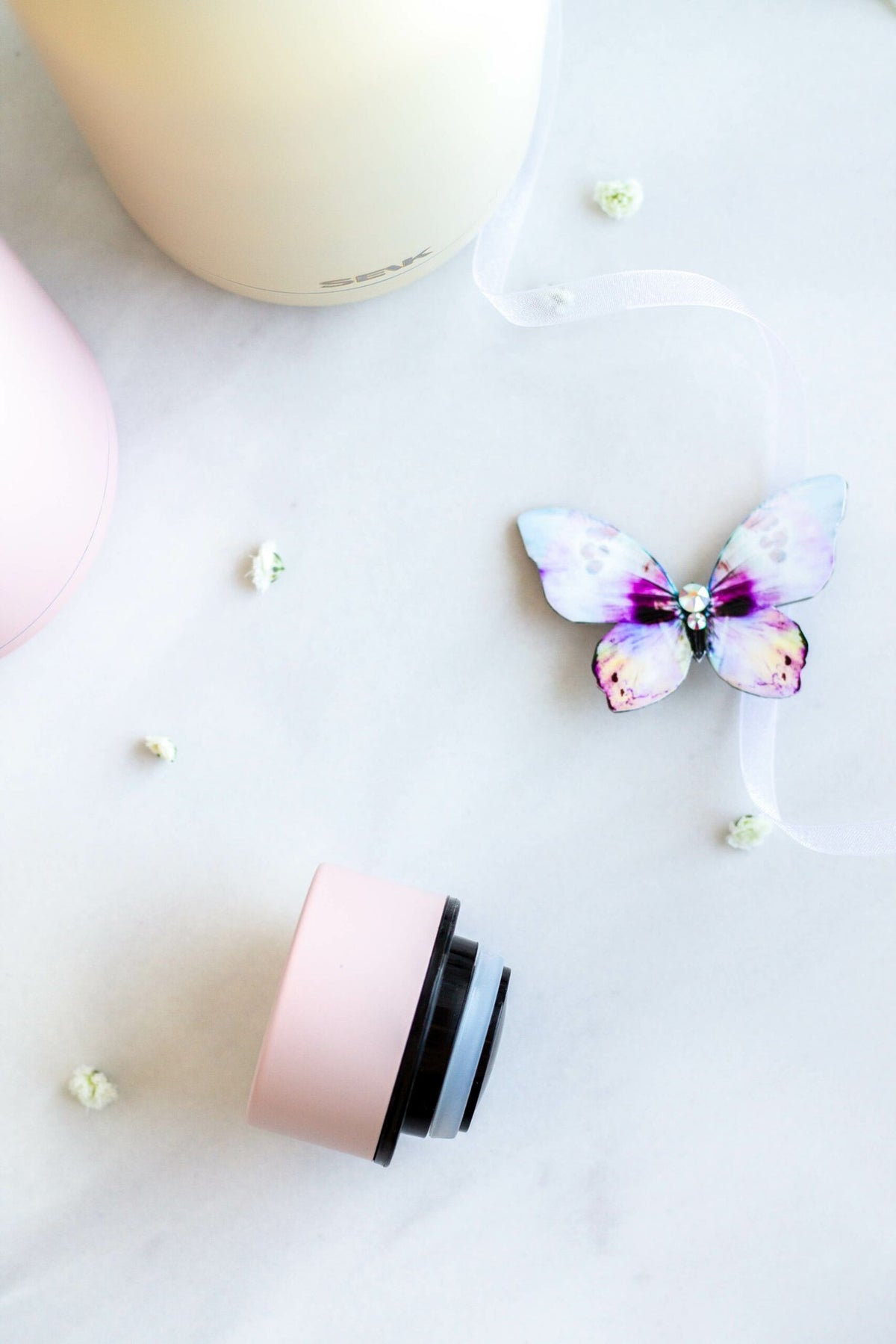 5. Close-up of SEIK pink water bottle cap with butterfly decor on marble surface