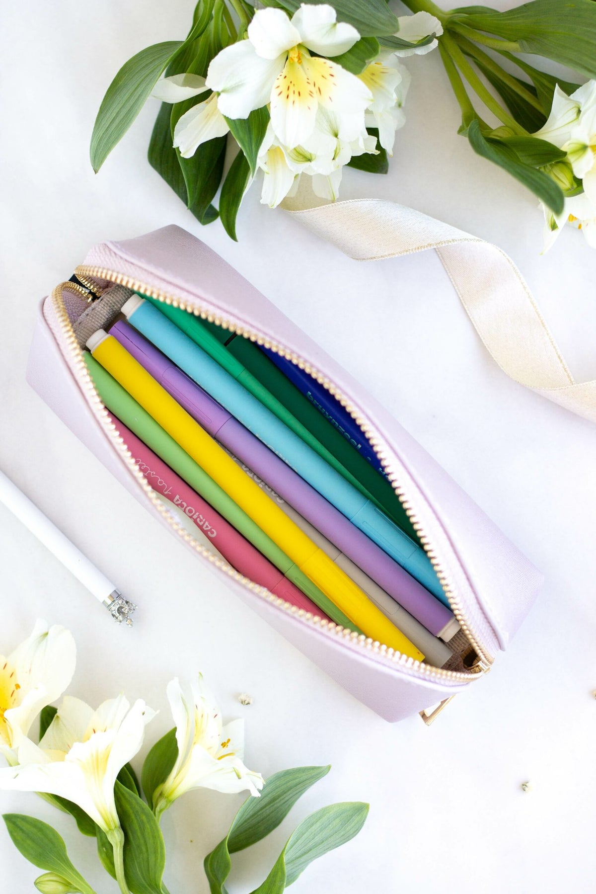 2. Open SEIK purple pencil case filled with colorful pencils, surrounded by flowers