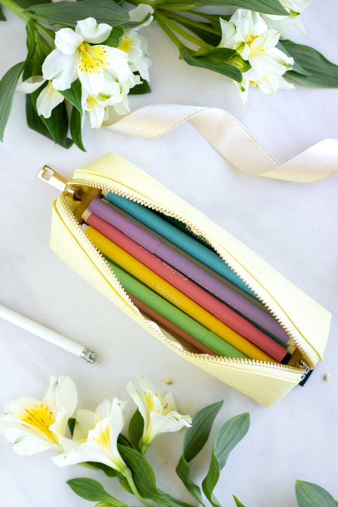 2. Open SEIK beige pencil case showing colorful pens inside, styled with flowers
