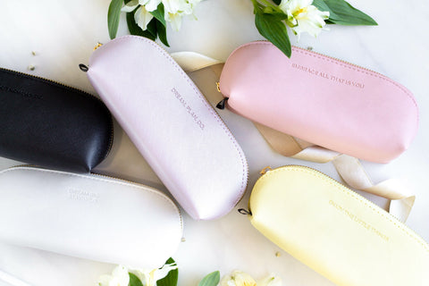 3. Collection of SEIK pencil cases in various colors with motivational phrases, styled with flowers