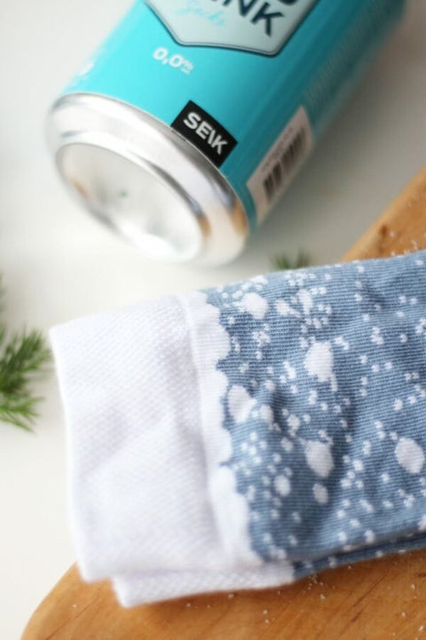 5. Close-up of SEIK Long Drink Socks in blue with white speckled design, next to Long Drink can