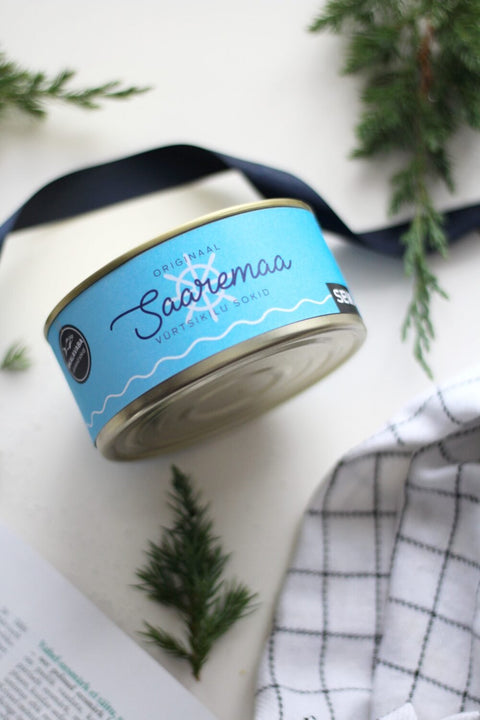 2. Close-up of Saaremaa Vürtsikilu Socks tin with blue label and SEIK logo, surrounded by greenery