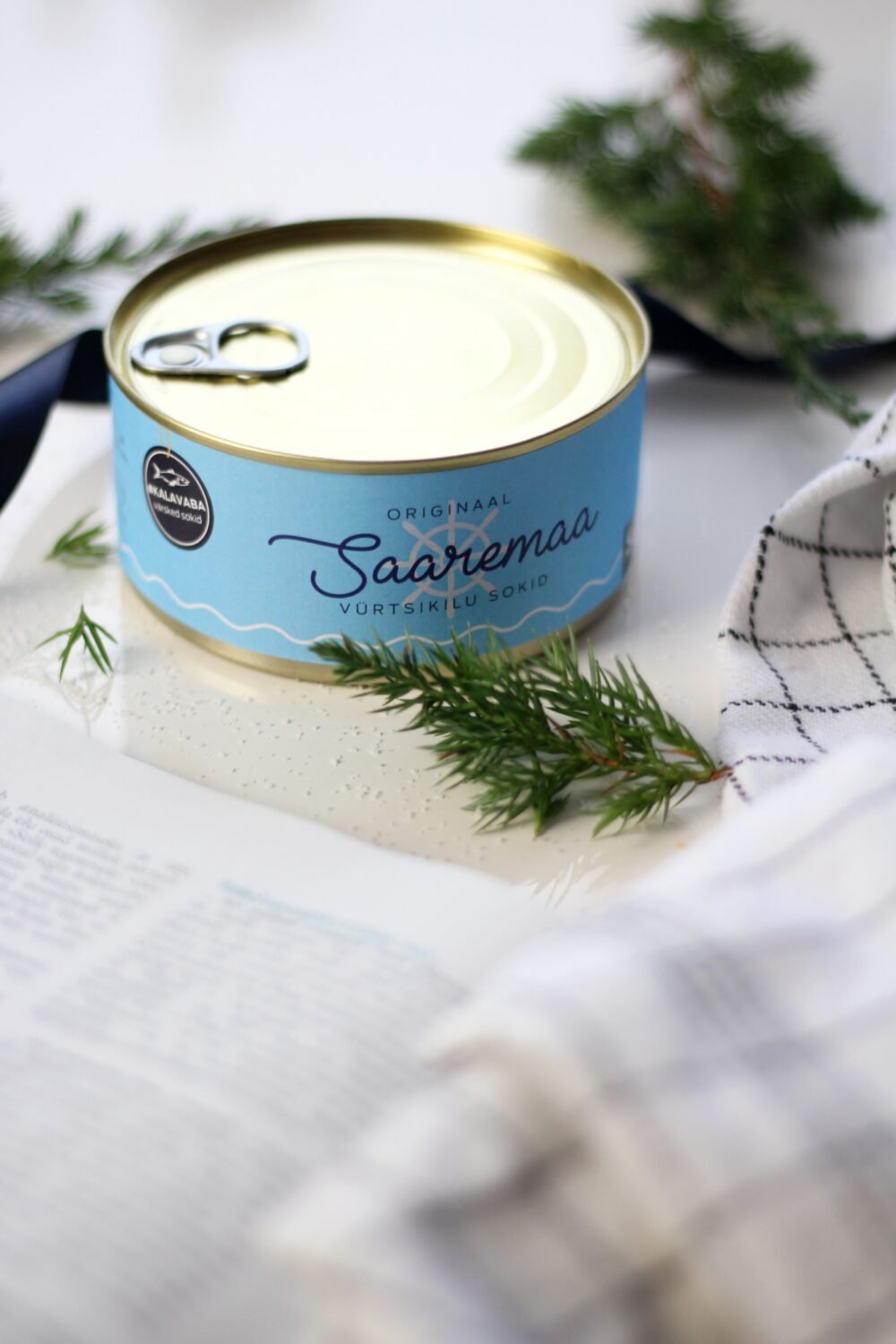 3. Saaremaa Vürtsikilu Socks tin with opener, styled with greenery and checkered cloth