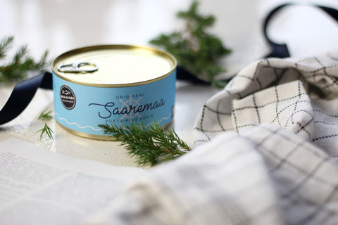 4. Saaremaa Vürtsikilu Socks tin with opener, styled with greenery and checkered cloth, side view