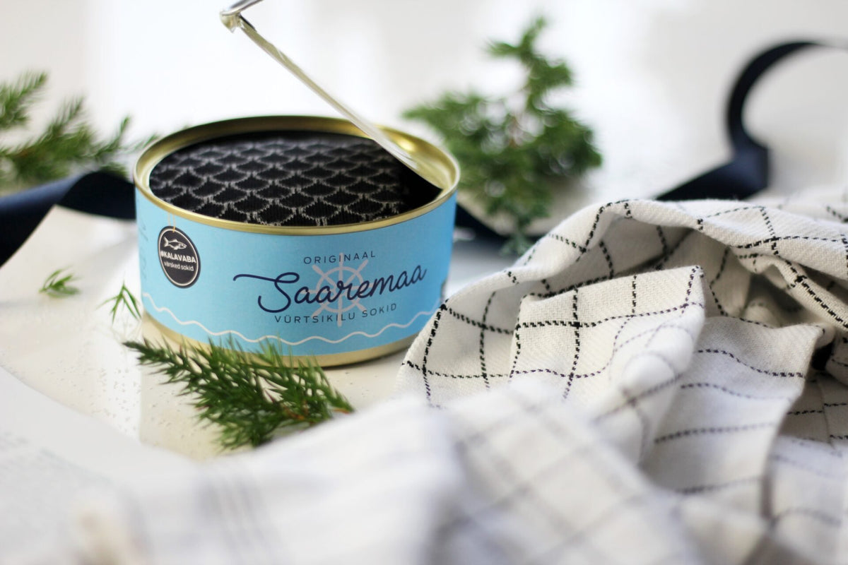 10. Open Saaremaa Vürtsikilu Socks tin with black patterned socks, styled with greenery and cloth