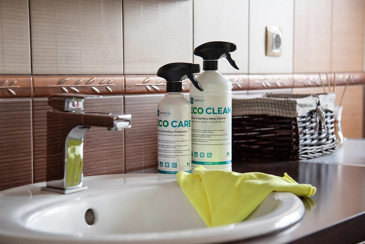1. GoGoNano EcoCare and EcoClean bottles on bathroom sink with yellow cloth, showcasing eco-friendly cleaning products