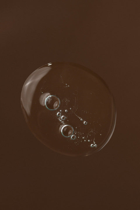3. Close-up of a clear gel bubble on a brown background, representing the texture of the intimate wash gel