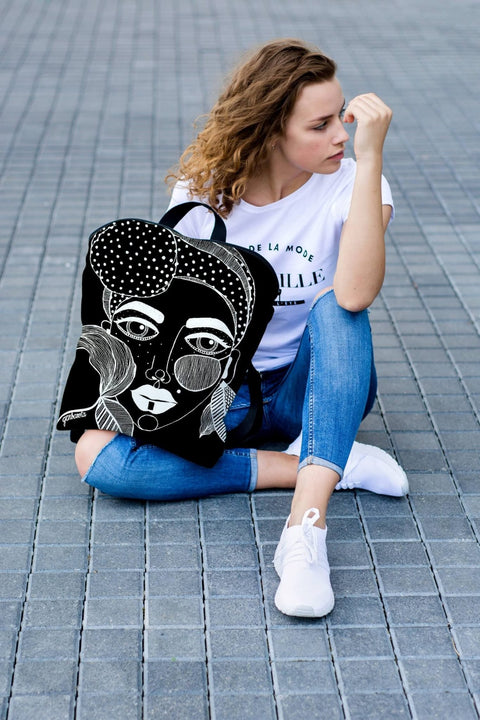 2. Woman posing with Garbanota black backpack, showcasing artistic design