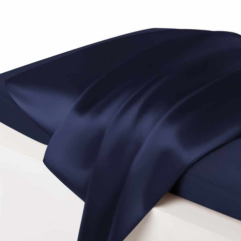 5. Close-up of navy blue silk pillowcase on bed, highlighting glossy finish