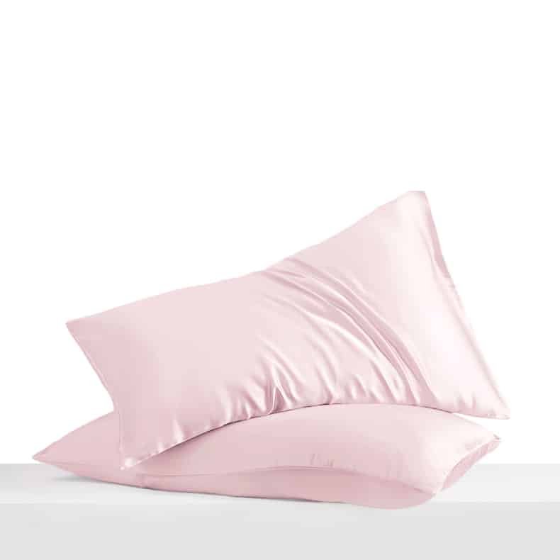 18. Pair of powder pink Mulberry silk pillowcases on a white surface, emphasizing softness