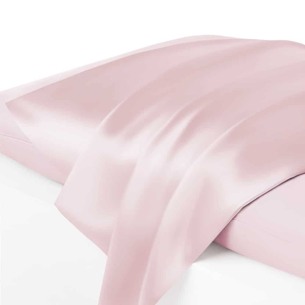 10. Close-up of light pink silk pillowcase on bed, showcasing smooth texture