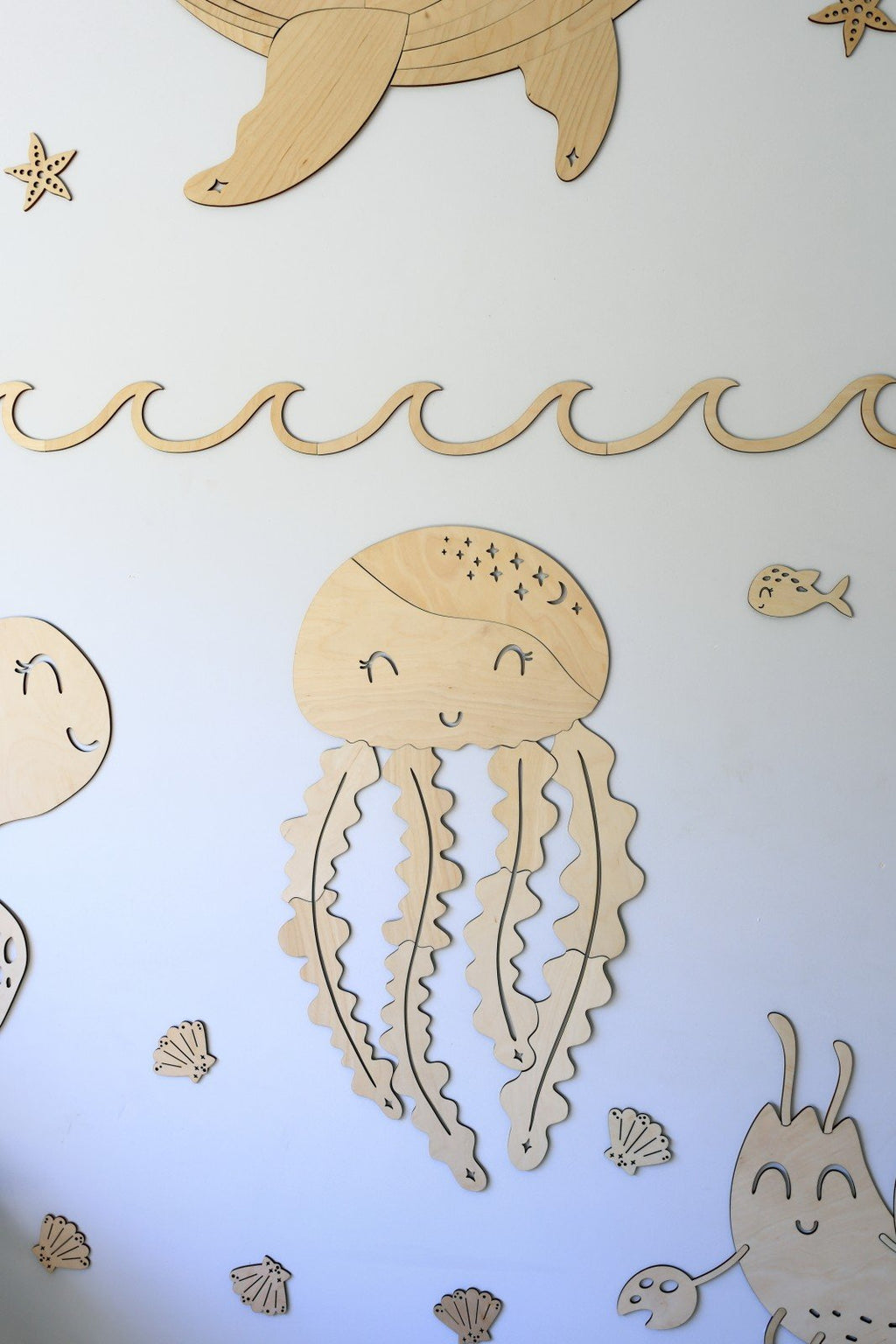 6. Wooden jellyfish wall decoration with smiling face and wavy tentacles surrounded by sea-themed extras