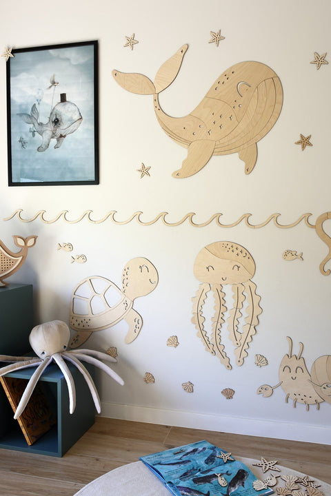 1. Ocean-themed room with wooden jellyfish wall decoration and sea creatures like whale and turtle on white wall