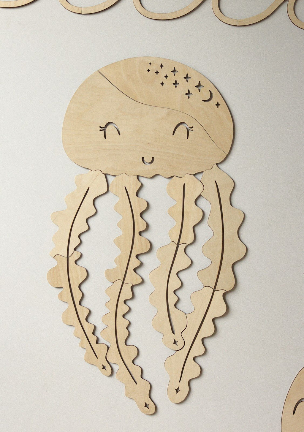2. Wooden jellyfish wall decoration with smiling face and wavy tentacles on white background