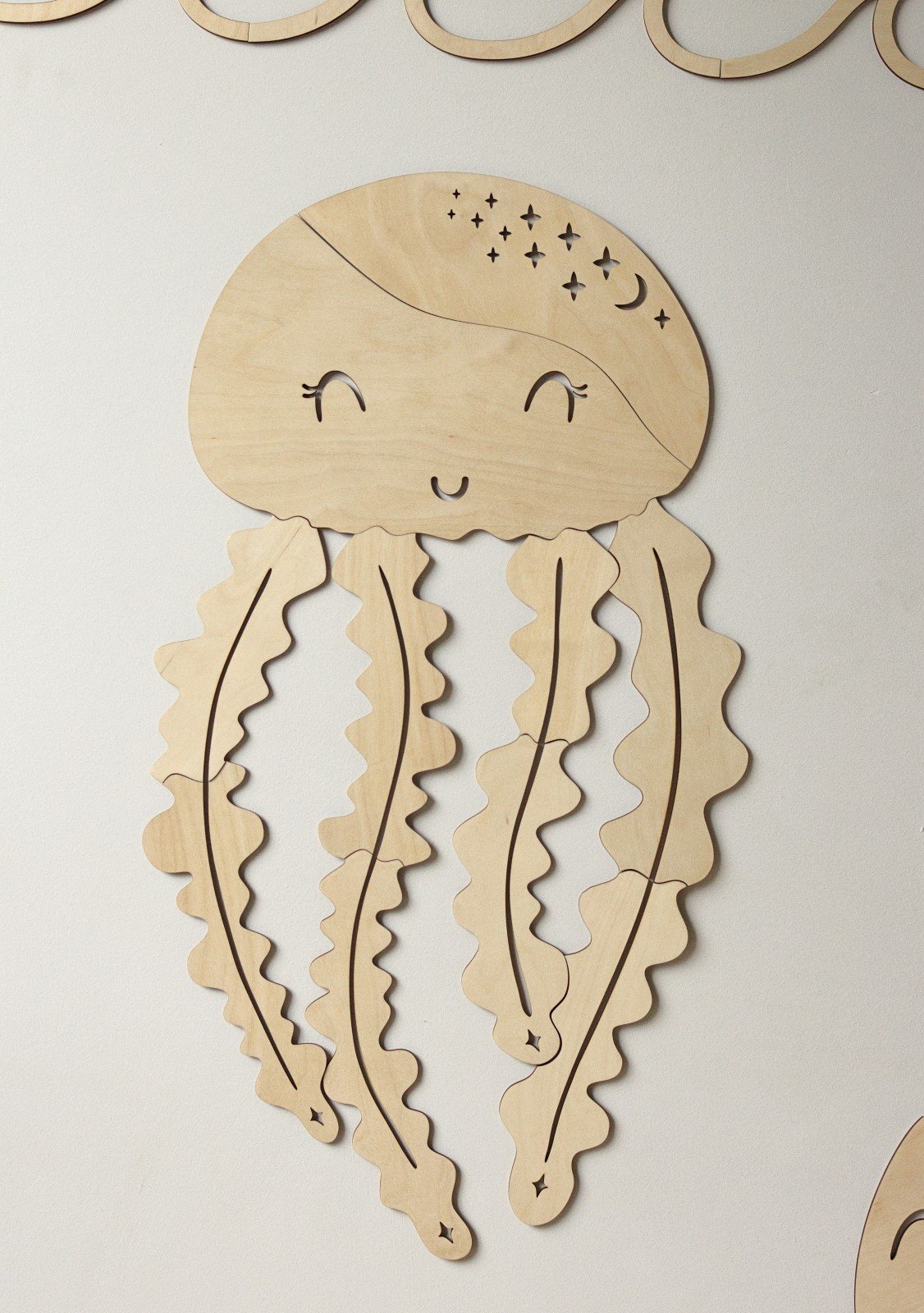 2. Wooden jellyfish wall decoration with smiling face and wavy tentacles on white background