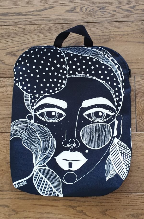 3. Studio shot of Garbanota black backpack with distinctive artwork on wooden floor