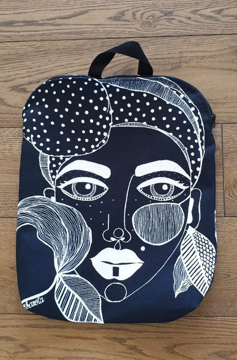 3. Studio shot of Garbanota black backpack with distinctive artwork on wooden floor