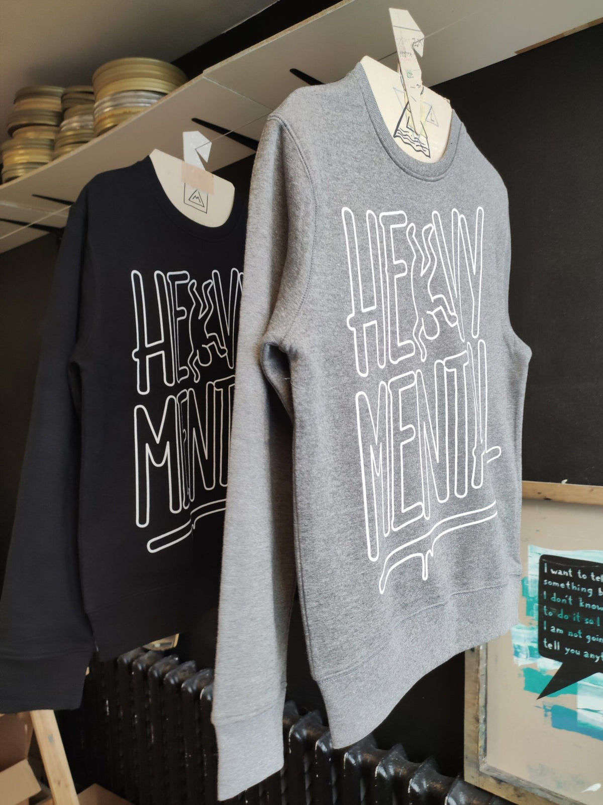 2. Grey and black Heavy Mental sweatshirts with Keith Haring-inspired prints, displayed in a studio setting
