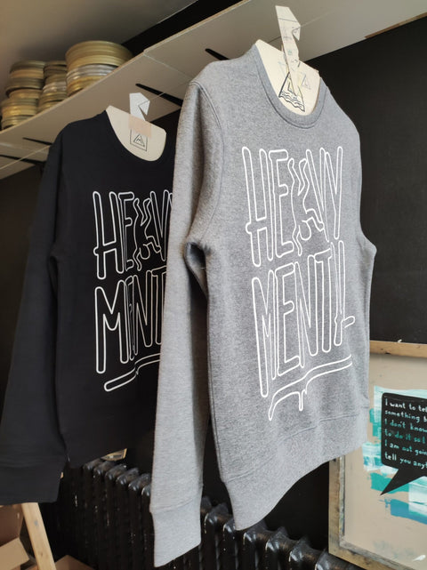2. Grey and black Heavy Mental sweatshirts with Keith Haring-inspired prints, displayed in a studio setting