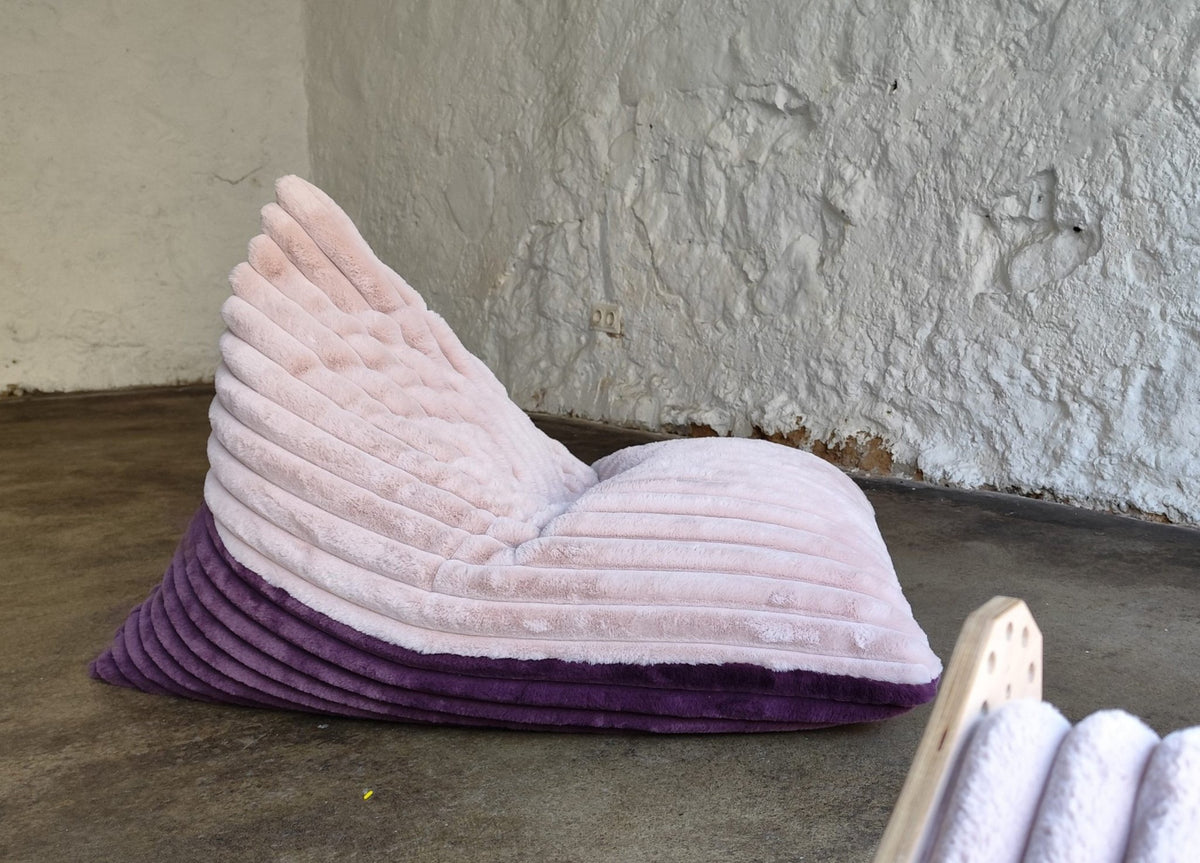 2. Luula kids bean bag chair in berry and rose mousse tones on a concrete floor, showcasing its ribbed plush texture and supportive design