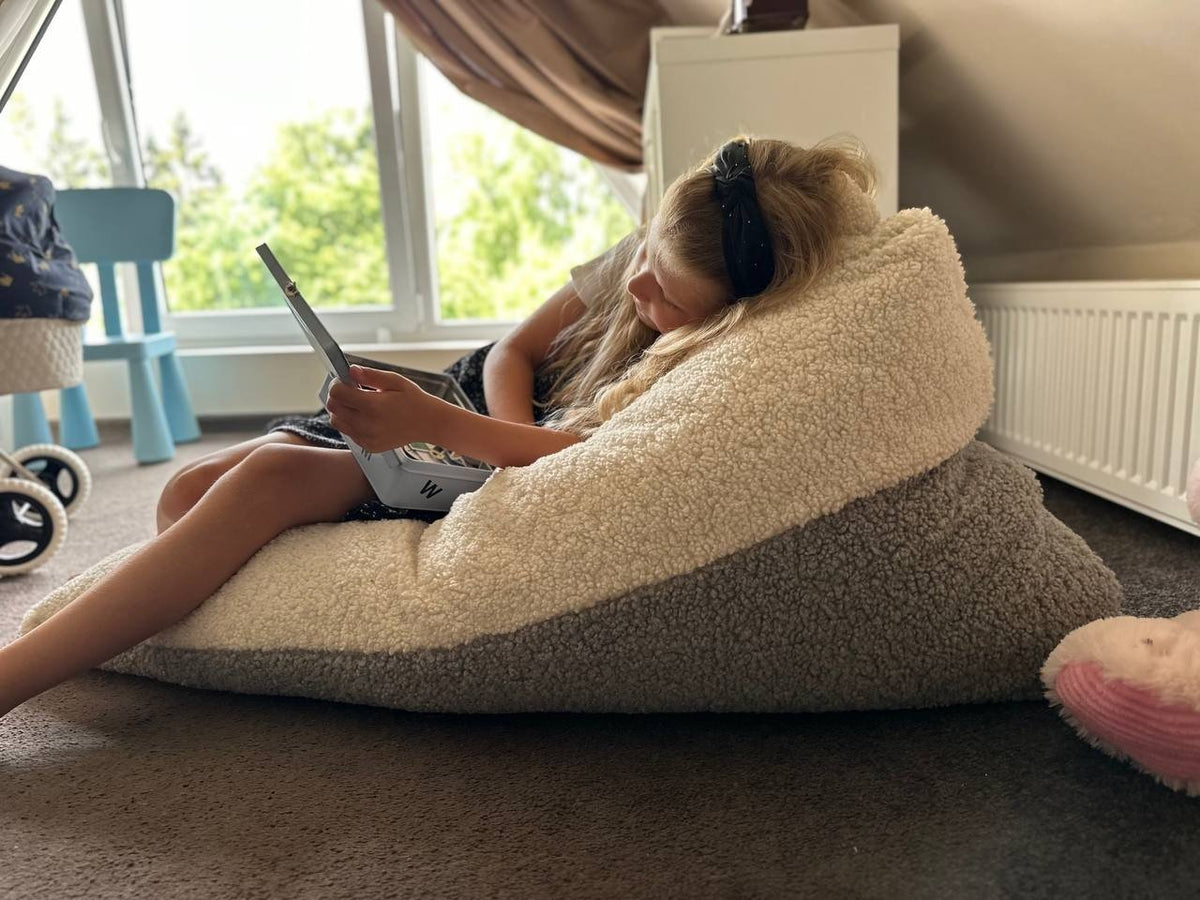 1. Girl lounging on Luula Kids Bean Bag Chair in two-tone sherpa, reading a book in a cozy room