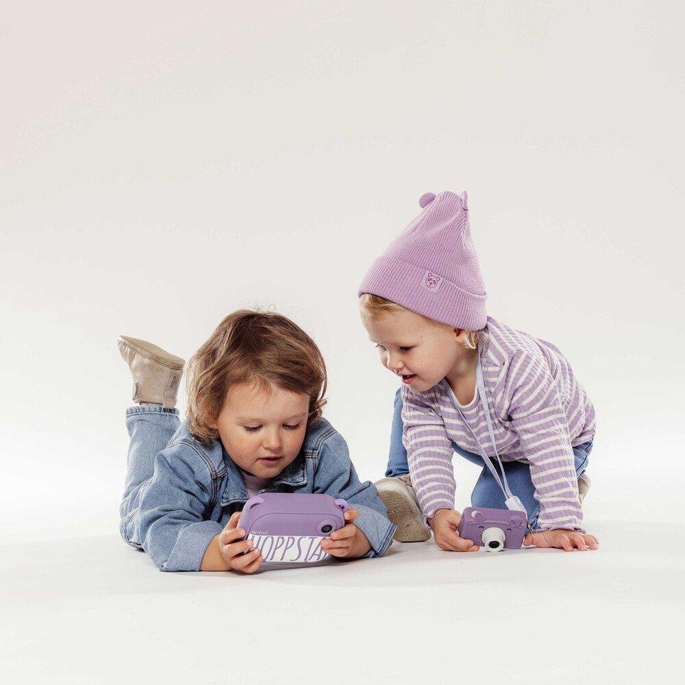 1. Two children playing with purple Hoppstar cameras on white background
