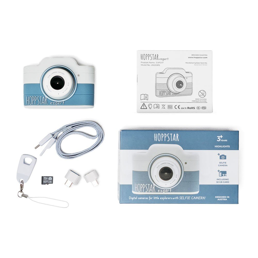 4. Flat lay of blue Hoppstar Expert children's camera with accessories including lanyard and adapters