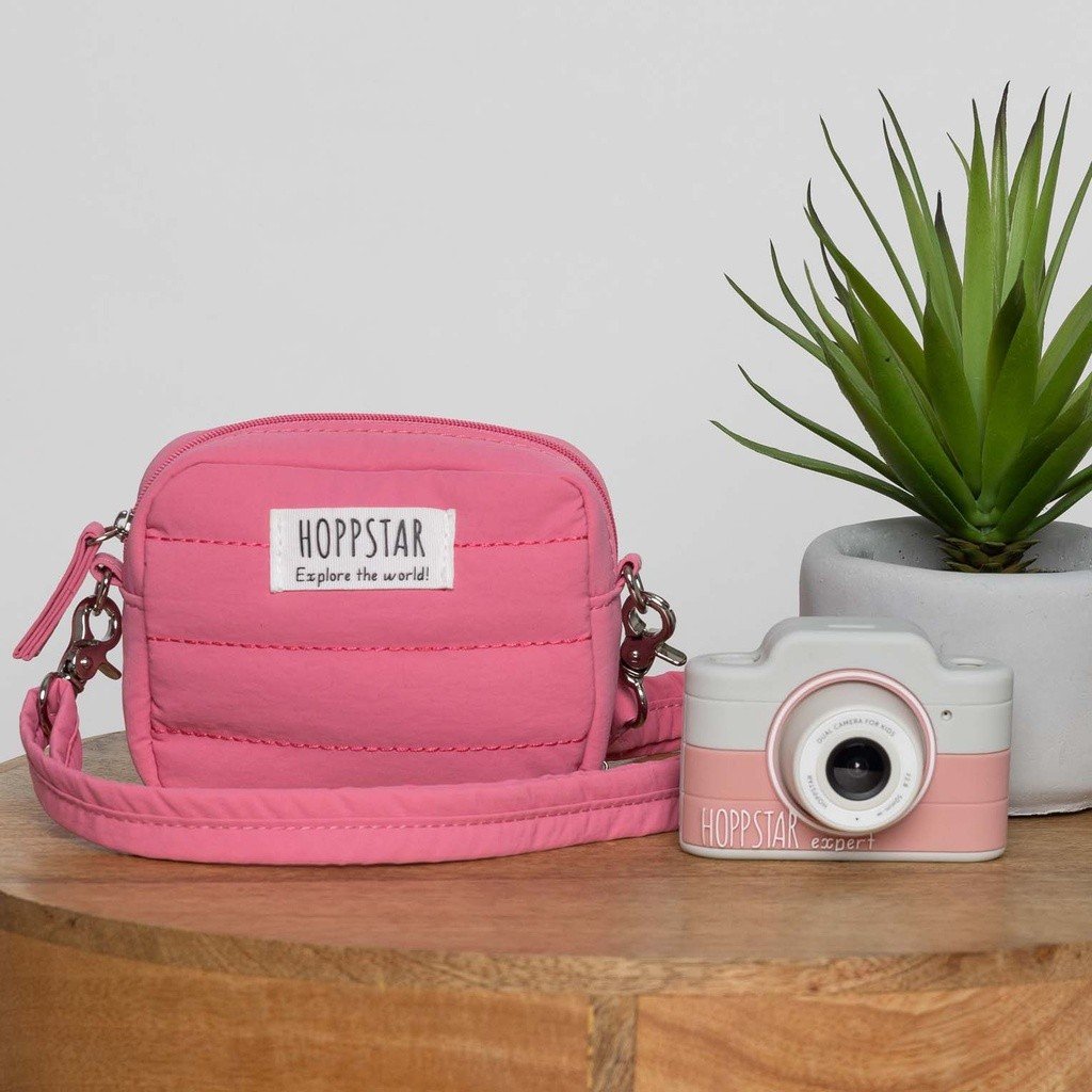 1. Pink Hoppstar Expert camera with matching bag on wooden table, plant in background
