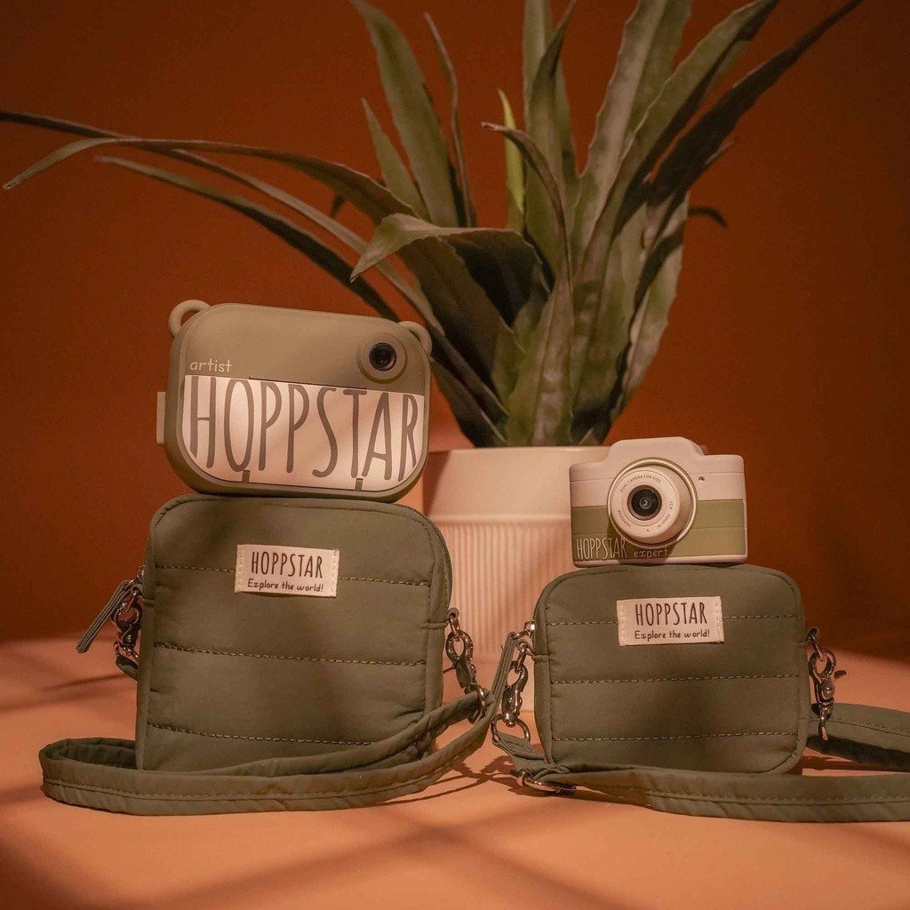 1. Green Hoppstar Expert camera with matching bags on wooden surface, plant in background