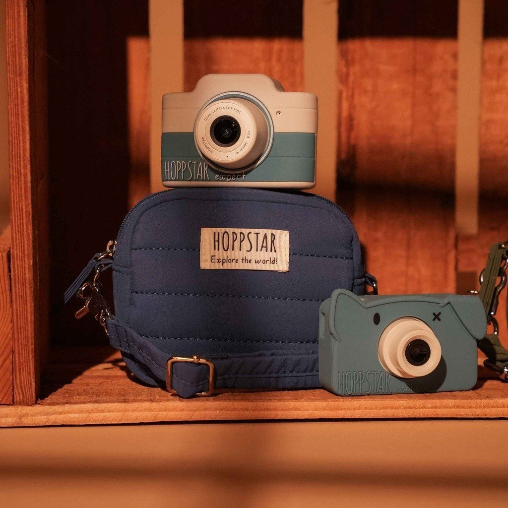 1. Blue Hoppstar Expert camera with matching bag on shelf, warm lighting