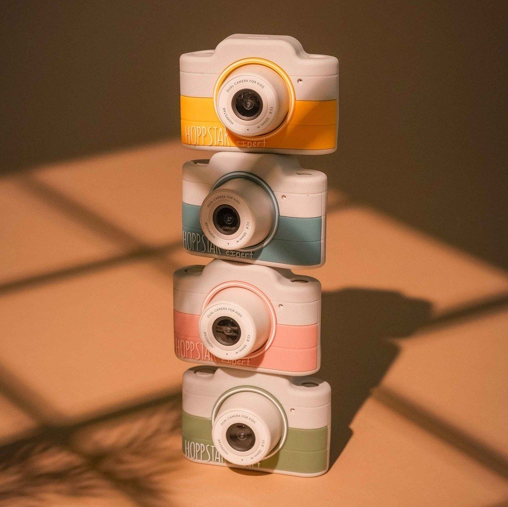 1. Four Hoppstar Expert cameras in different colors stacked vertically, warm lighting