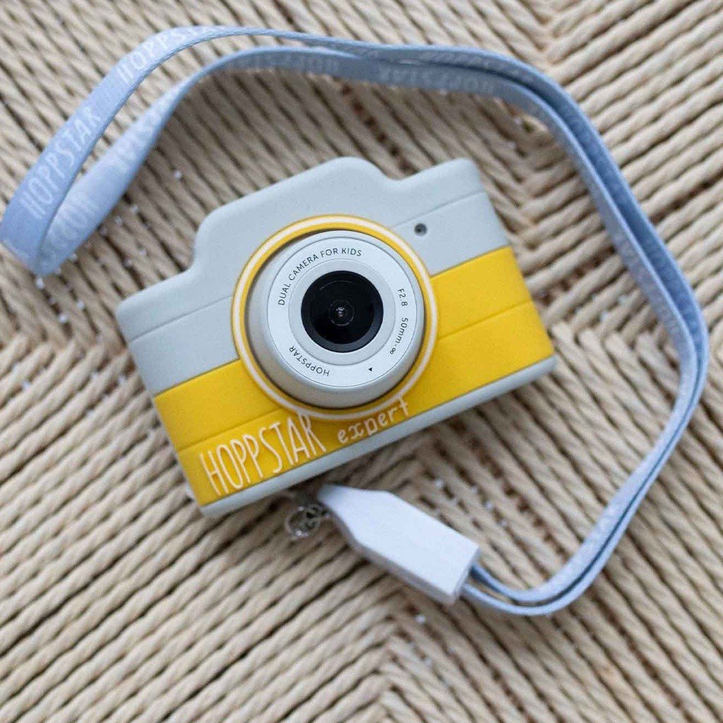 1. Yellow Hoppstar Expert camera with lanyard on woven surface