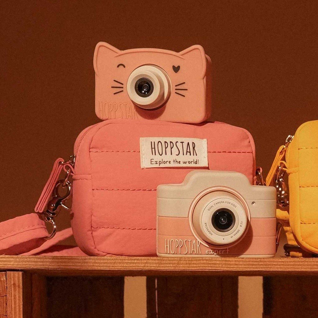 1. Pink Hoppstar Expert camera with matching bag on shelf, warm lighting