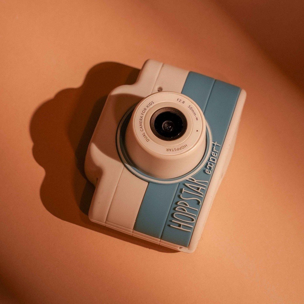 3. Blue Hoppstar Expert camera on peach background, angled view