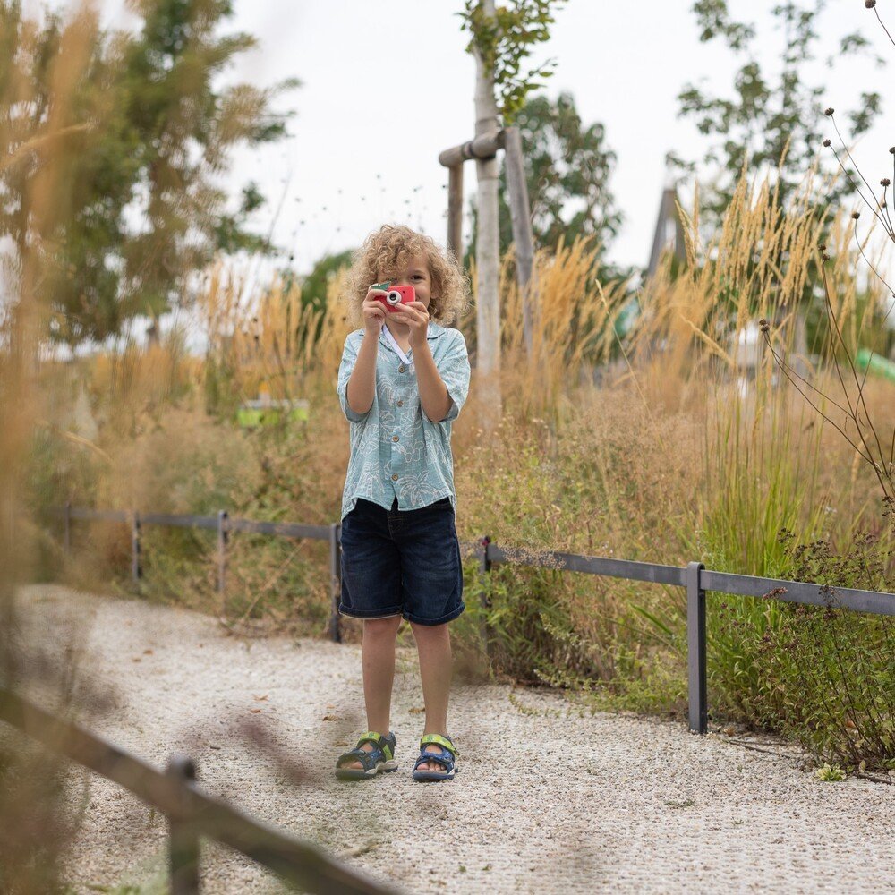 1. Boy using pink Hoppstar Rookie camera in natural park setting