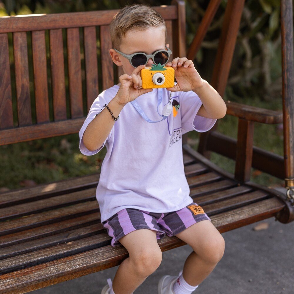 1. Boy using pink Hoppstar Rookie camera in park, wearing casual outfit
